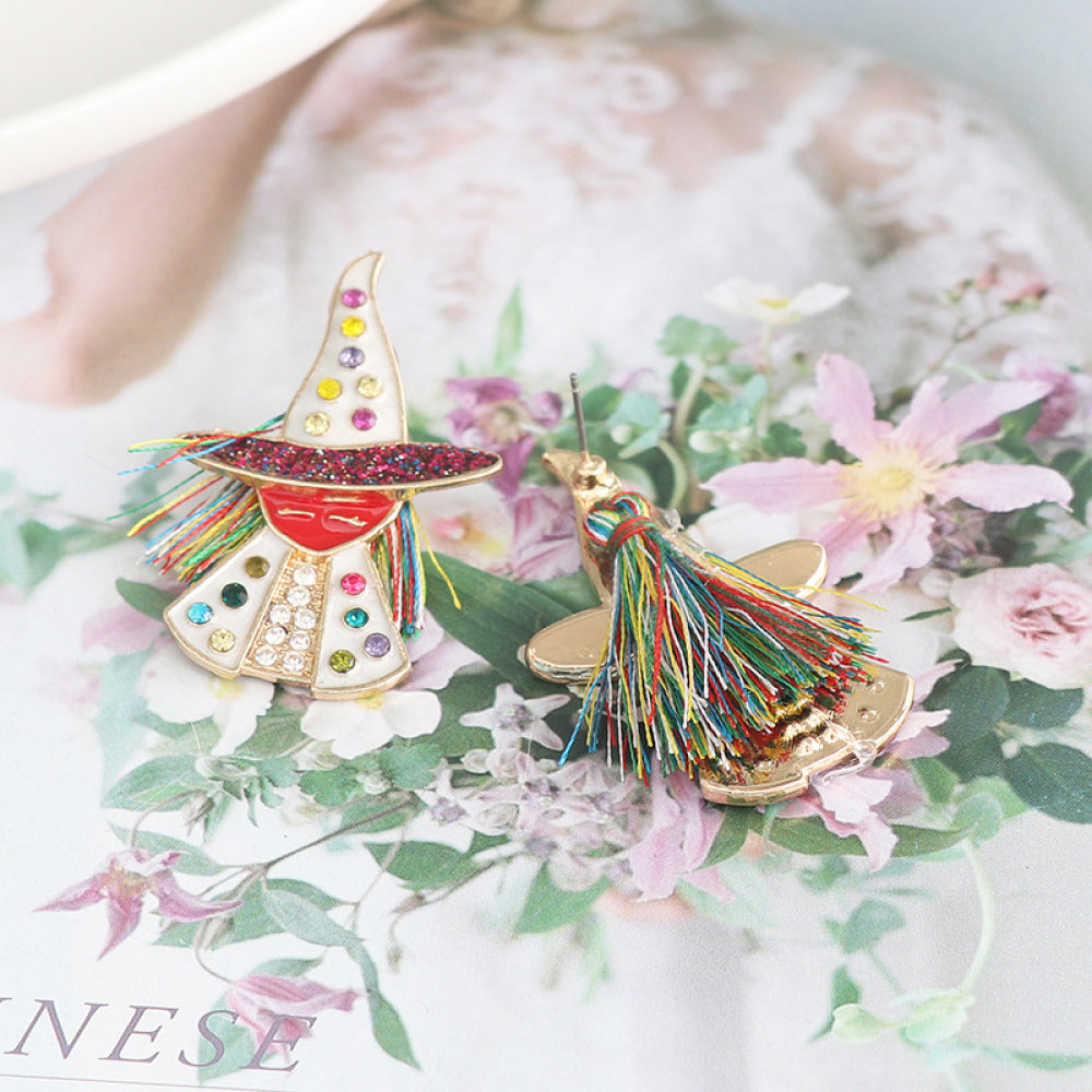 Two colorful witch-themed rhinestone alloy earrings are displayed on a floral background.
