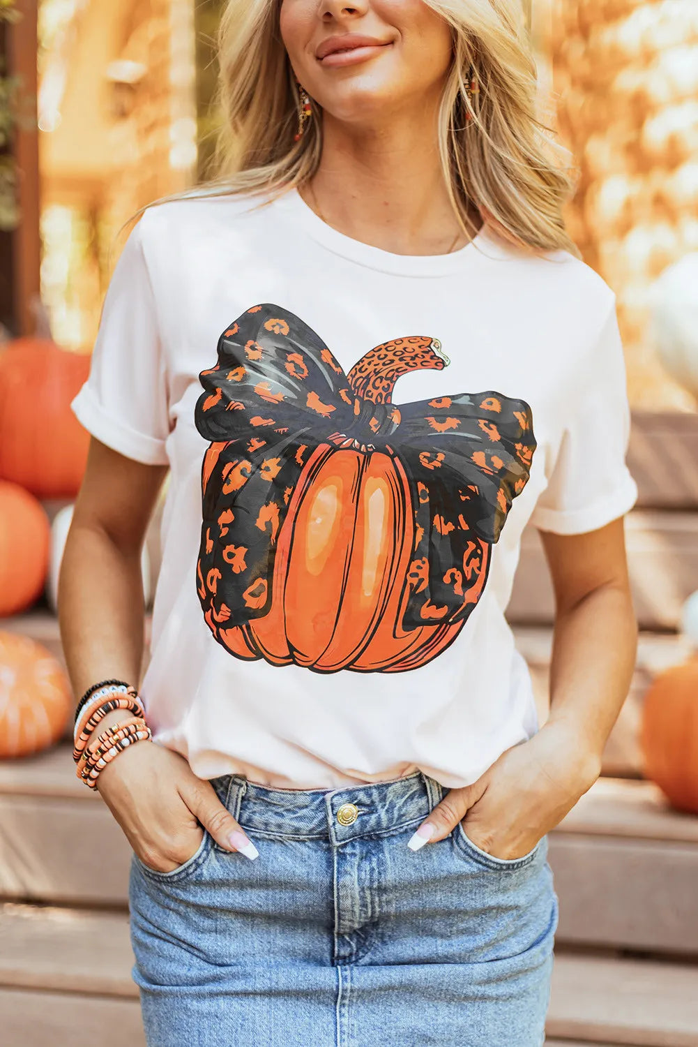 A woman wears a white short-sleeve t-shirt with a leopard print pumpkin design.
