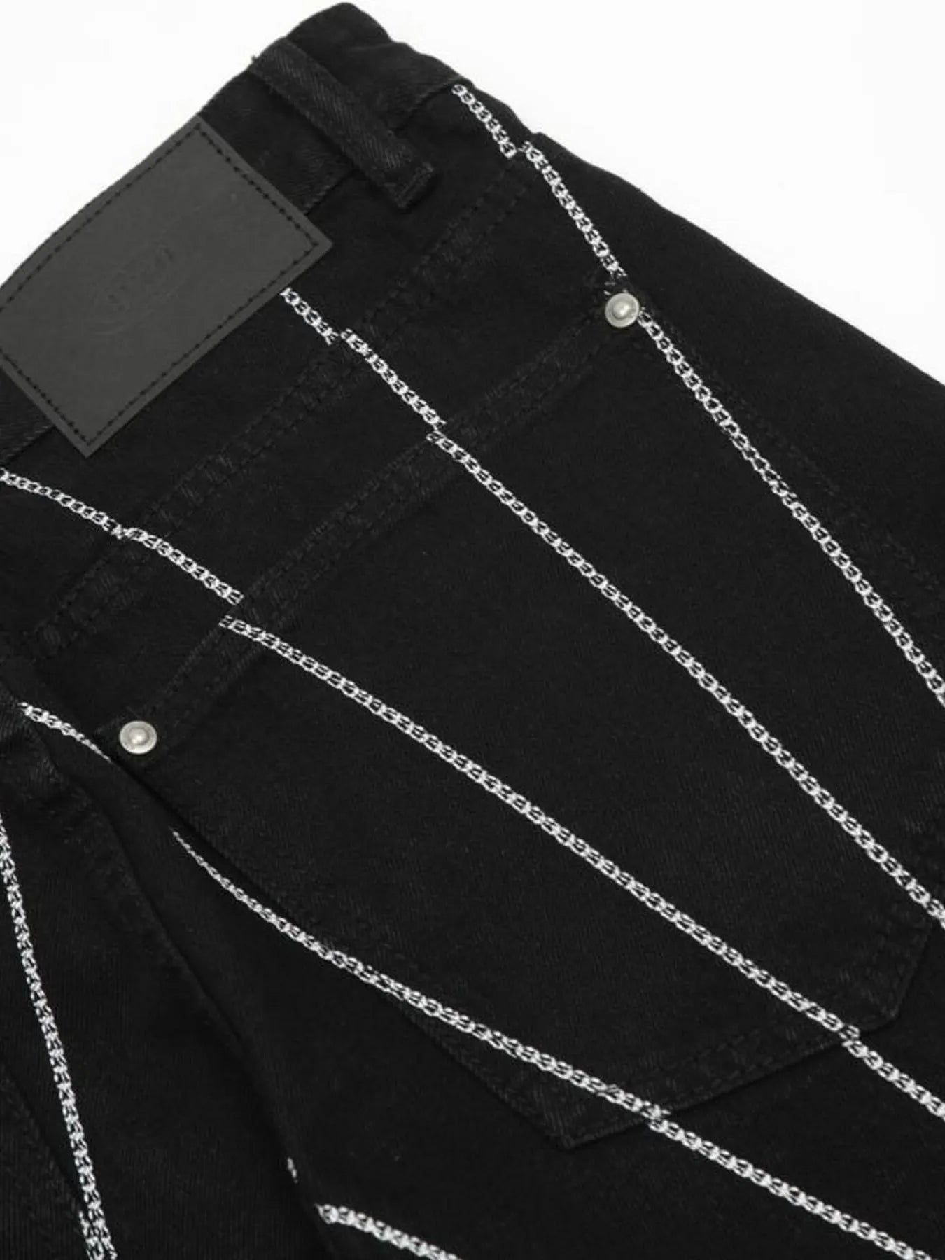 Black jeans with white chain-link embroidery and a black leather patch on the back.