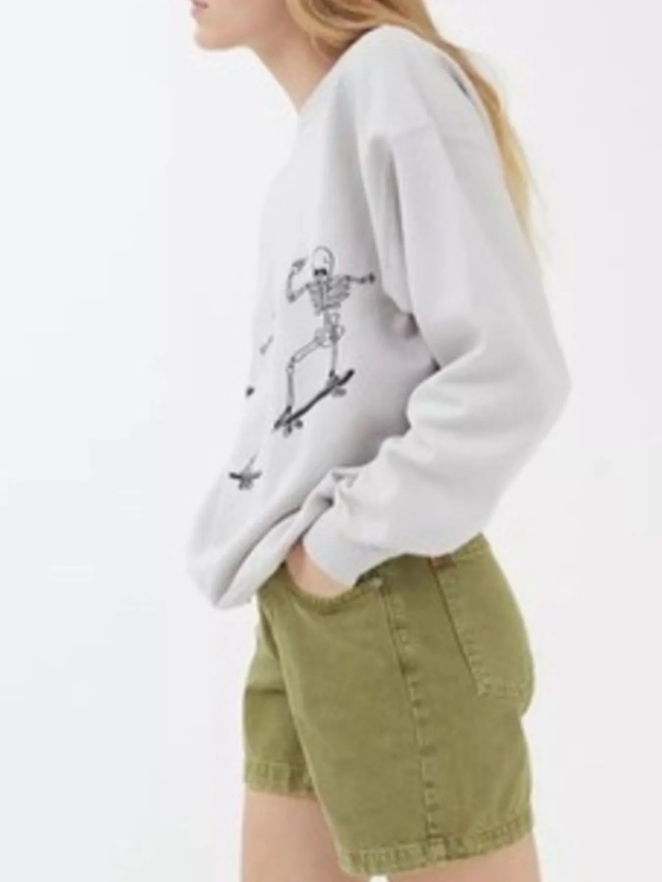 Oversized sweatshirt with a skeleton graphic, paired with olive green shorts.