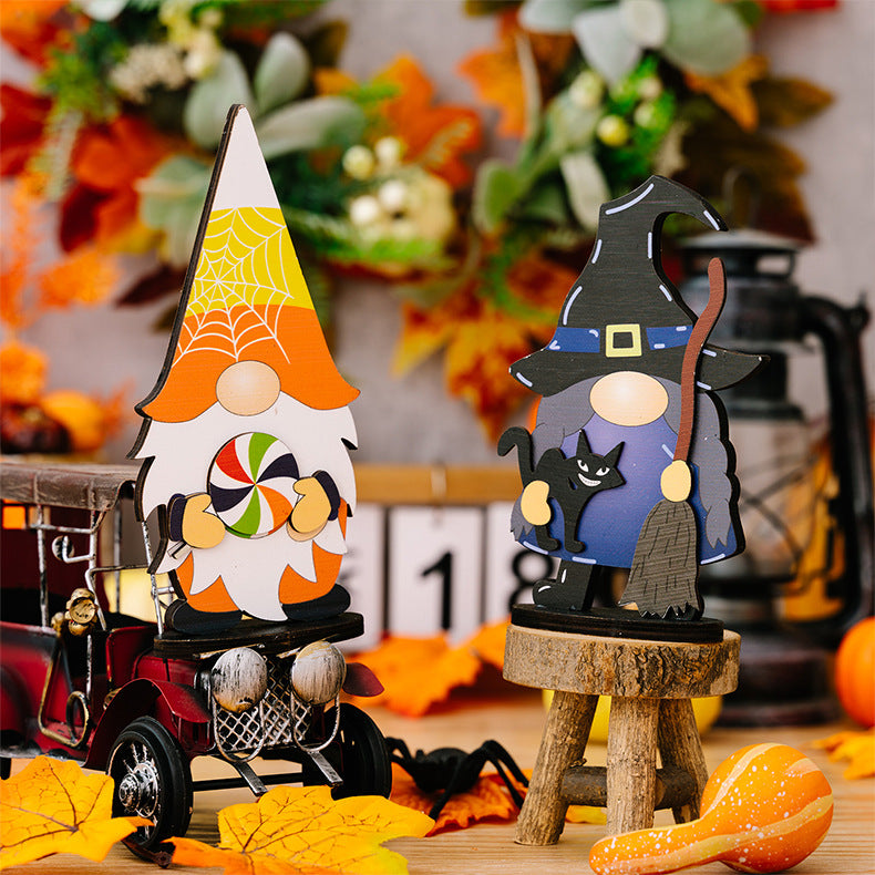 Two Halloween gnome ornaments, one with a lollipop and one with a cat and broom.