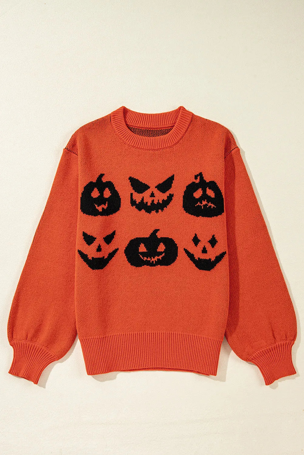 An orange round neck sweater features six black pumpkin faces.