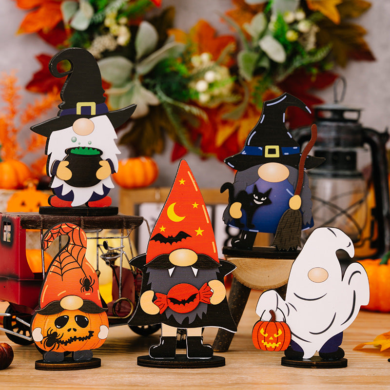 Six wooden Halloween gnome and ghost ornaments are displayed on a wooden surface.