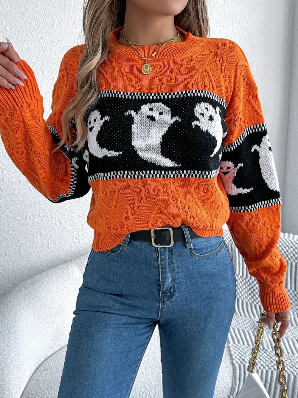 Orange long-sleeve sweater with a black and white ghost pattern.