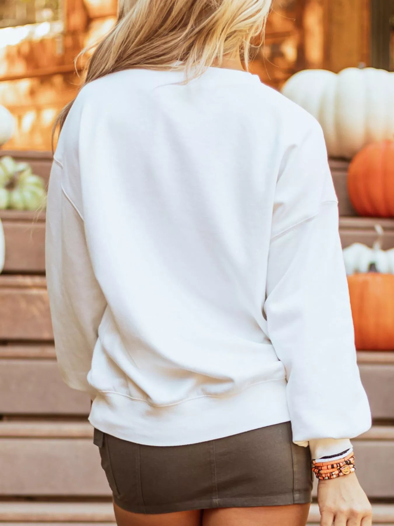 White long sleeve sweatshirt with a Halloween pumpkin patched pattern.