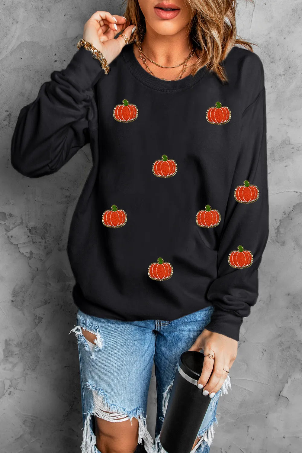 Black long-sleeve sweatshirt with sequin pumpkin appliques.