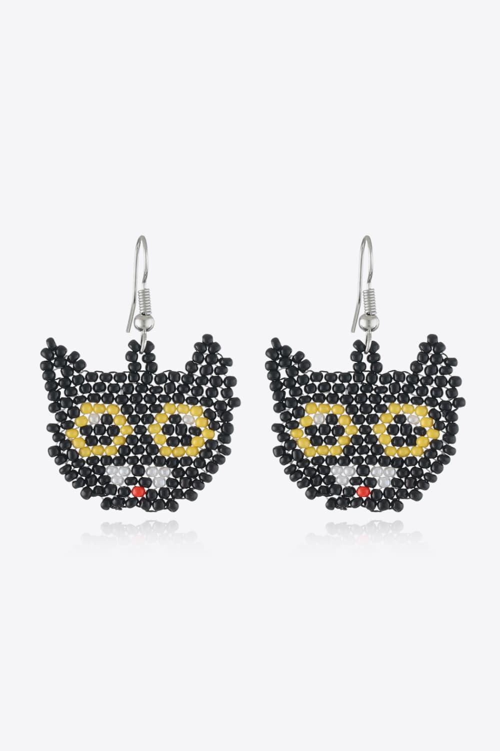 A pair of black beaded cat-face earrings with yellow eyes and a red nose.