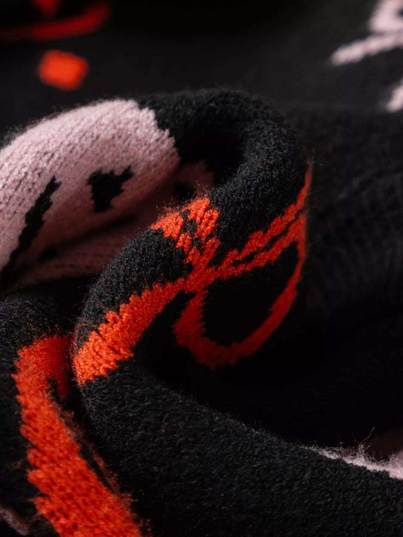Close-up of a black and orange Halloween pumpkin pattern button-up cardigan.
