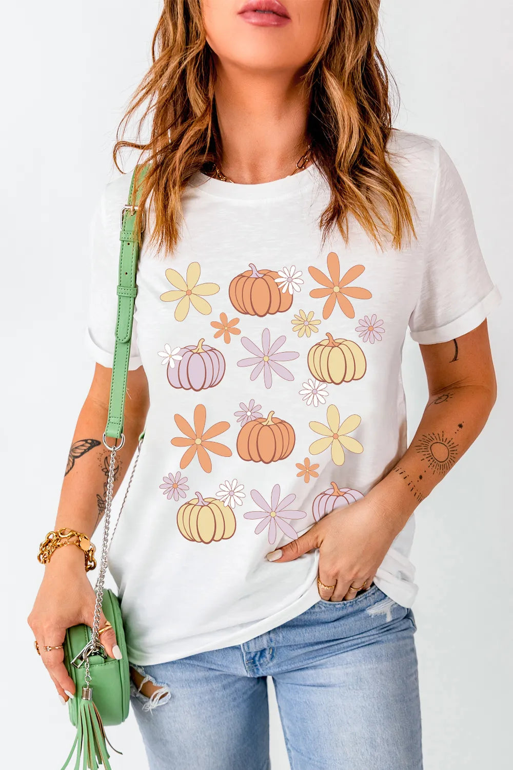 A woman wears a white short-sleeve t-shirt with pumpkin and flower graphics.