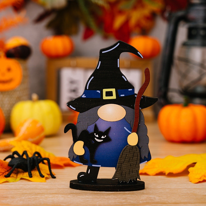 A wooden Halloween gnome ornament with a witch hat, black cat, and broom.
