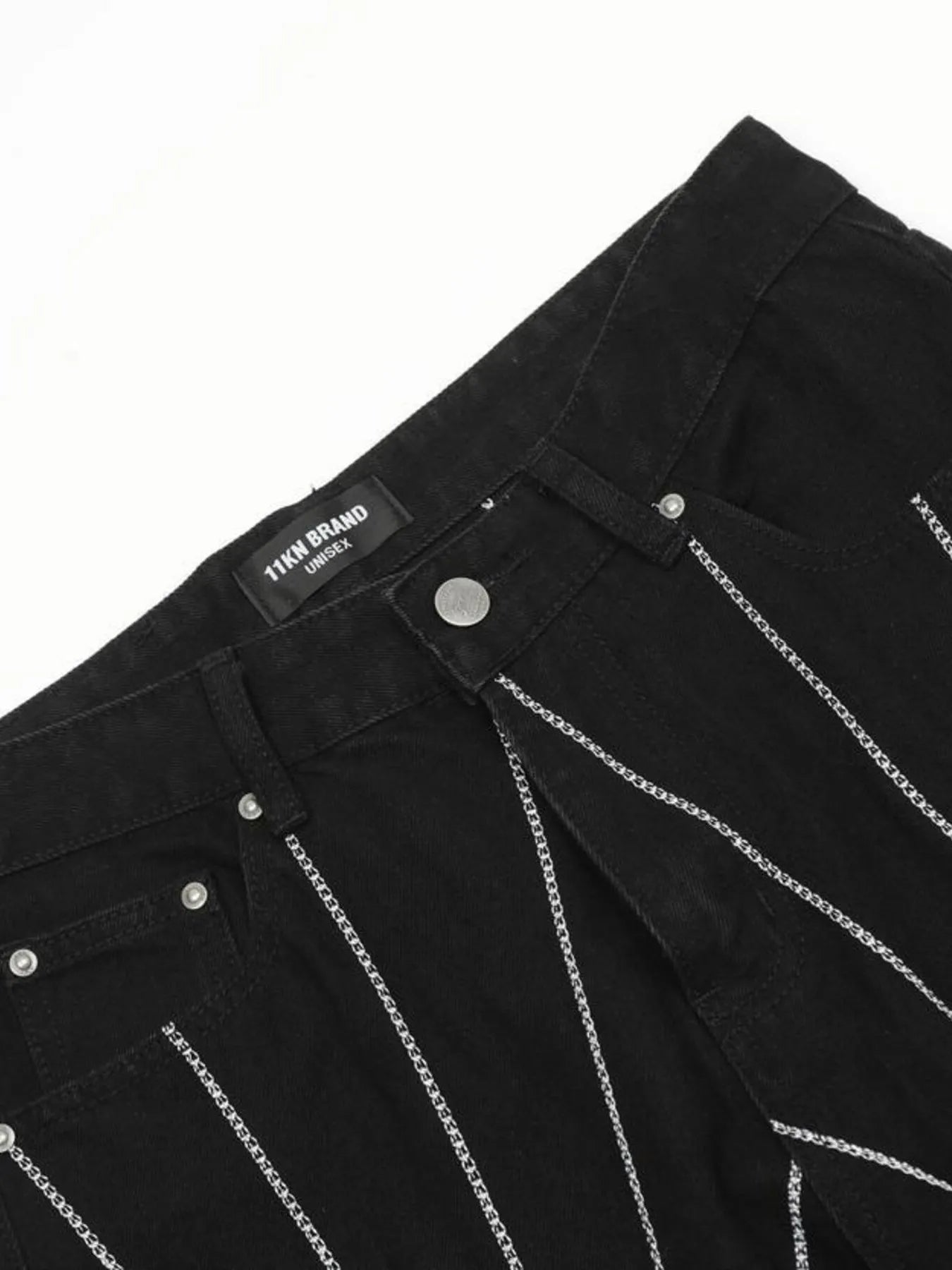Black jeans with a "11KN BRAND UNISEX" label and silver chain details.