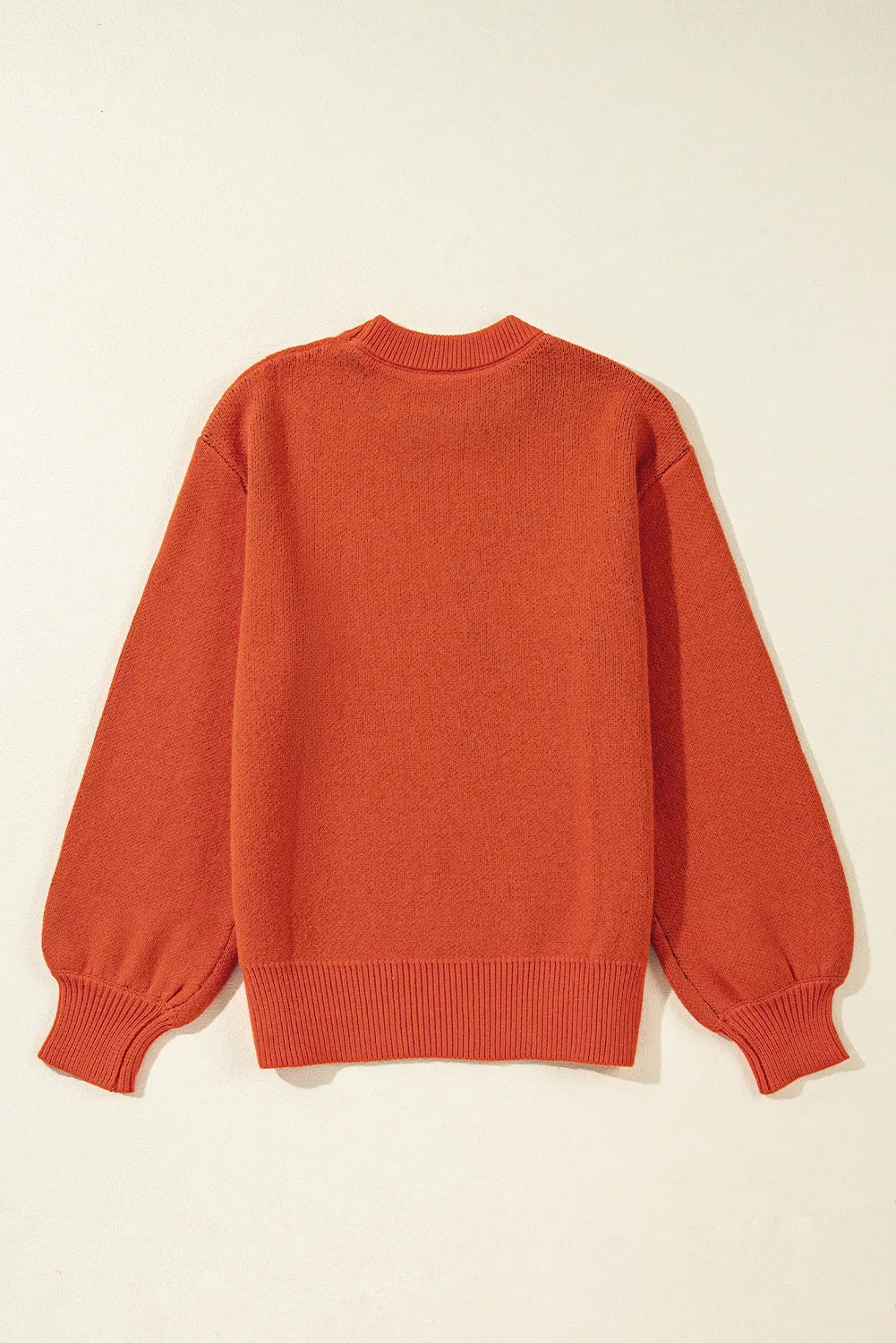 A pumpkin-colored round neck sweater with long balloon sleeves is shown from the back.