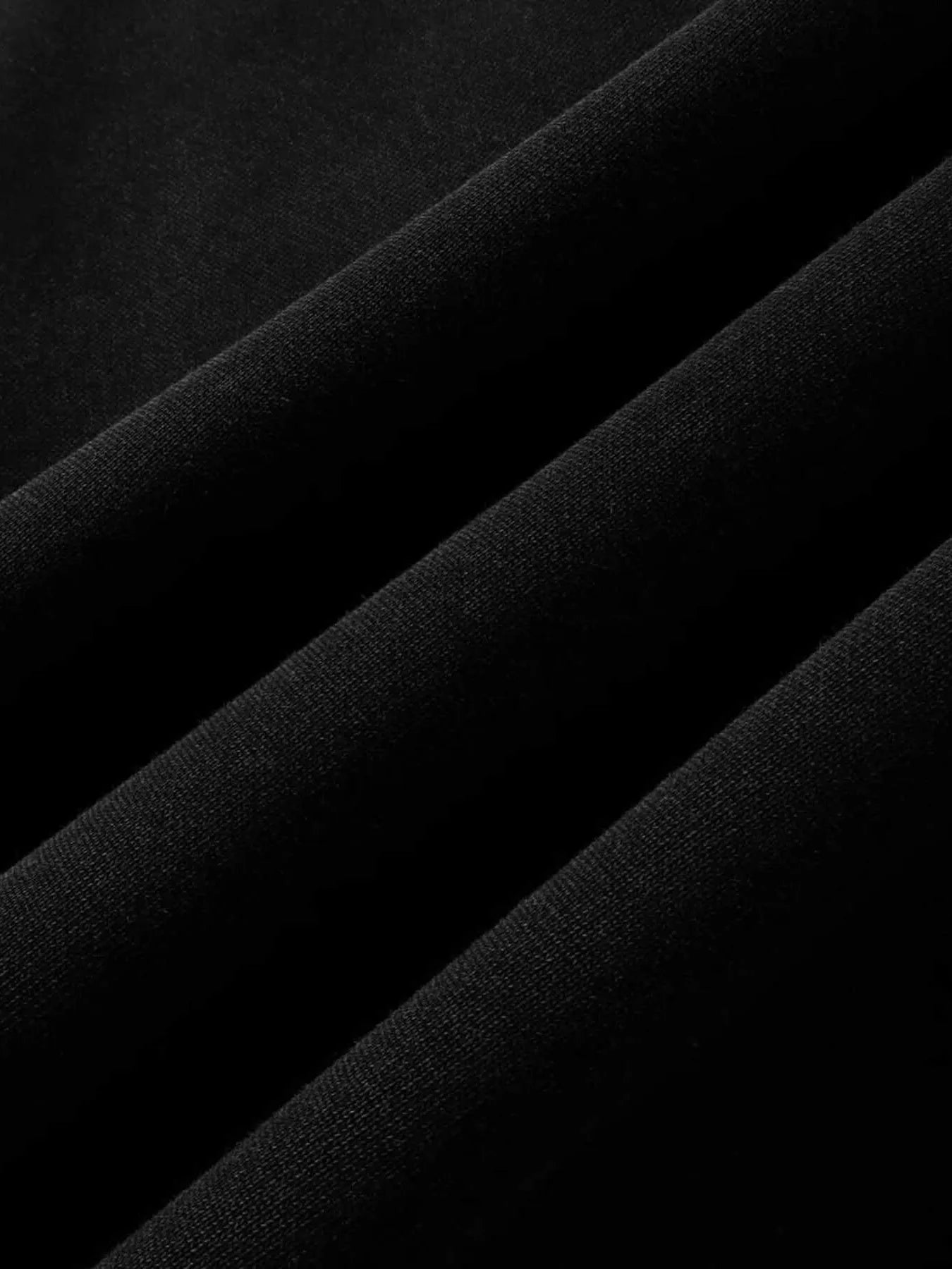 Close-up of folded black fabric, likely cotton-polyester blend.