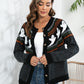 A woman wears a black button-up cardigan with white ghost patterns and colorful accents.