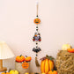 A Halloween hanging decoration featuring a pumpkin, a car with ghosts, and a bat.