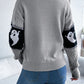 Gray long-sleeve sweater with black and white ghost designs on the sleeves.