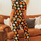 A woman from behind wears a pumpkin-printed short sleeve top and pants lounge set.