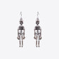 Two silver-colored skeleton alloy earrings hang against a white background.