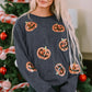 Sequin patch pumpkin round neck sweatshirt on a woman in front of a Christmas tree.
