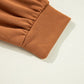 Close-up of a brown long-sleeve top with gathered fabric at the cuff.