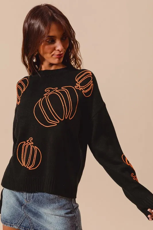Black knit sweater with orange pumpkin embroidery.