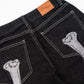 Black straight-leg jeans with white stitching and bone embroidery on the back pockets.