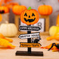 A wooden Halloween sign with a jack-o'-lantern on top and three directional arrows.