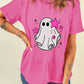 A woman wears a pink t-shirt with a ghost and pink stars graphic.
