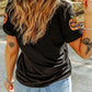 Black short-sleeve t-shirt with sequin pumpkins on the shoulders.