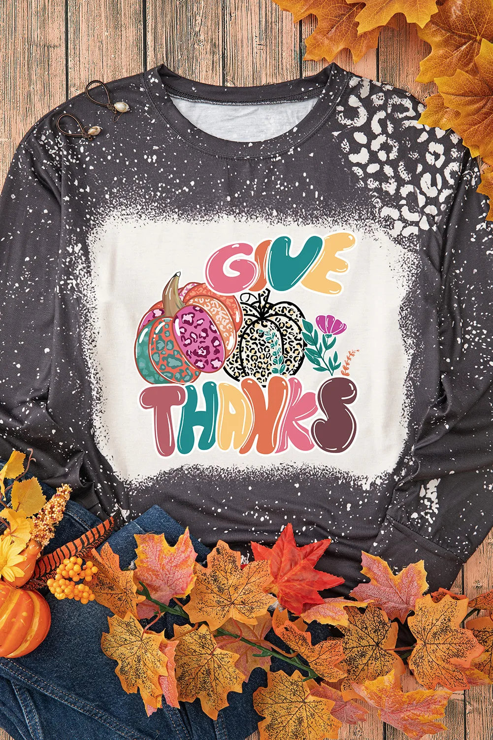 Black long-sleeve t-shirt with a bleached effect and "Give Thanks" pumpkin graphic.