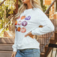 Pumpkin Graphic Long Sleeve Sweatshirt worn by a woman with long blonde hair and a denim skirt.