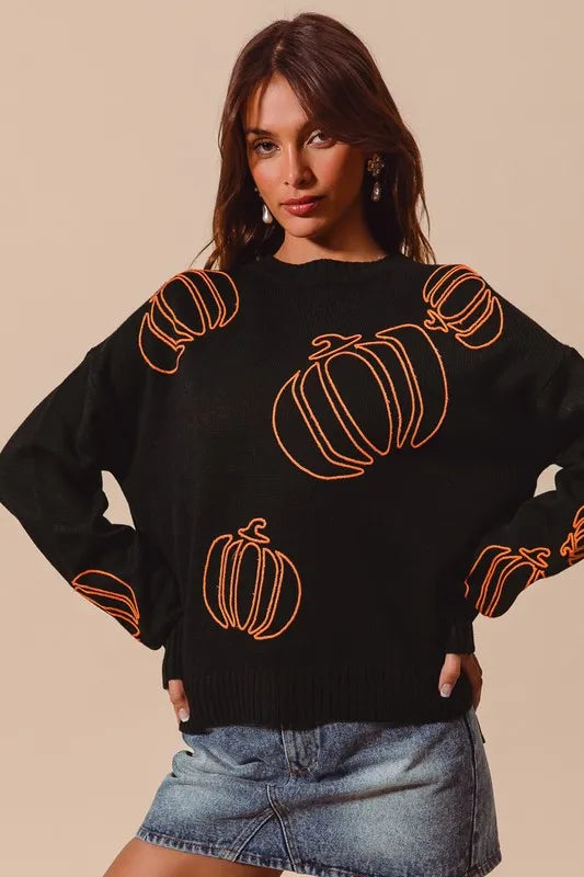 Black knit sweater with orange pumpkin embroidery.