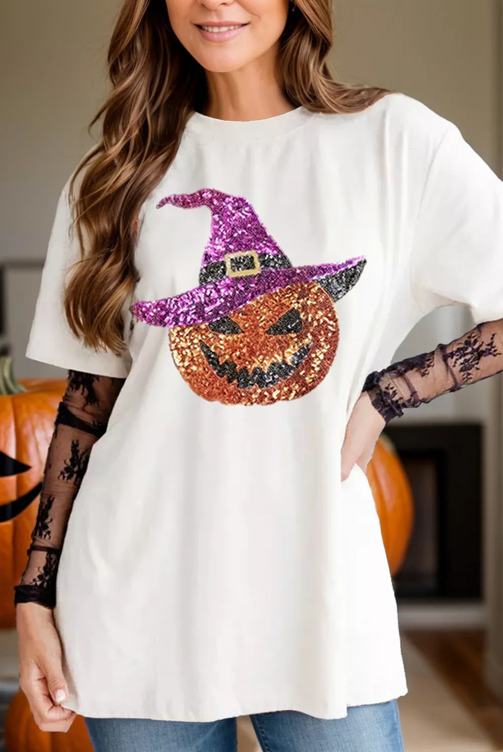 A woman wears a white short-sleeve t-shirt with a sequin pumpkin design.