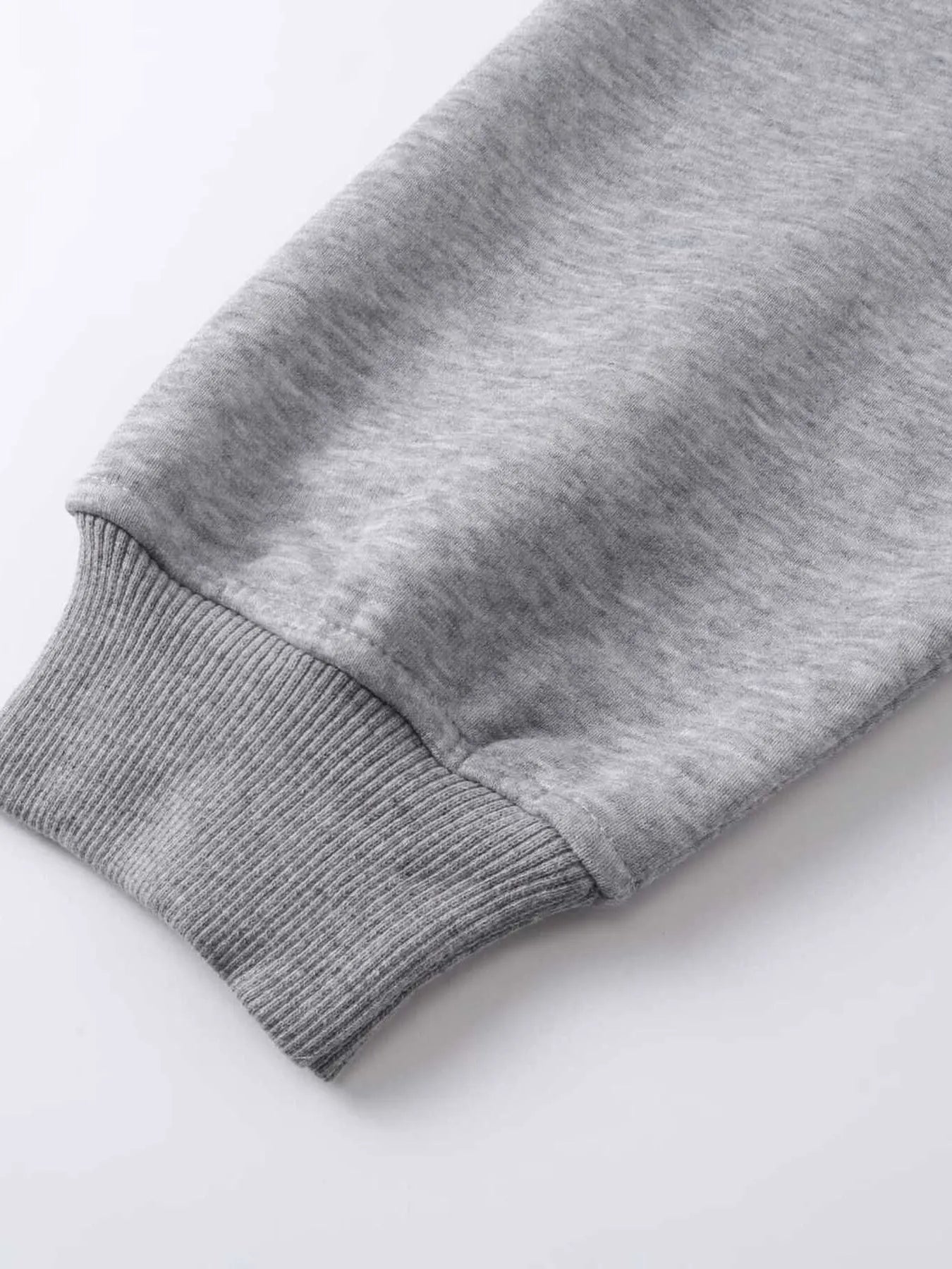 Close-up of a gray hoodie sleeve with a ribbed cuff.