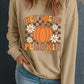 A woman wears a tan long-sleeve sweatshirt with a "Hey There Pumpkin" graphic.
