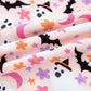 Pink fabric with a Halloween ghost, bat, moon, and flower print.