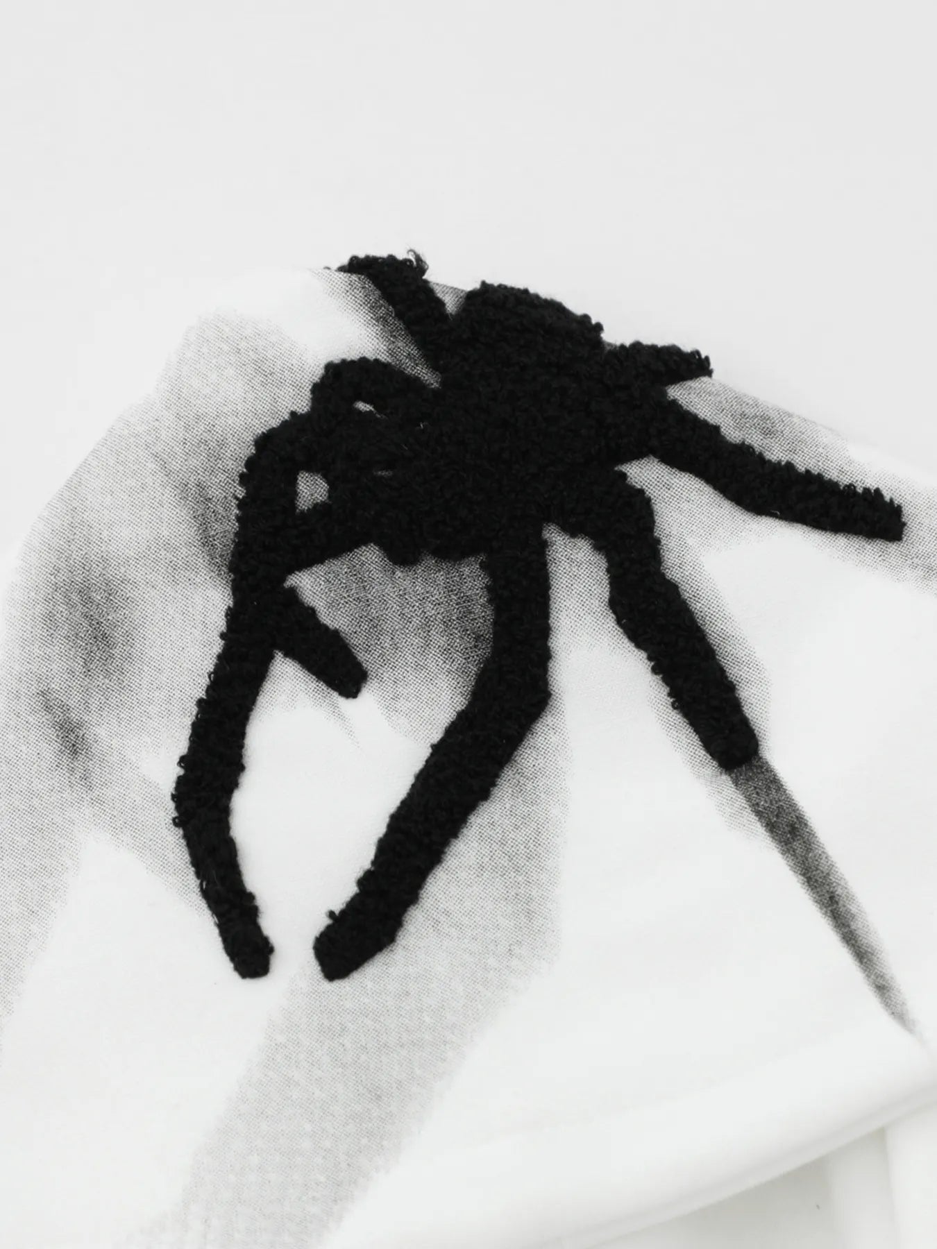 Men's oversized hoodie with a black spider graphic and side button details.