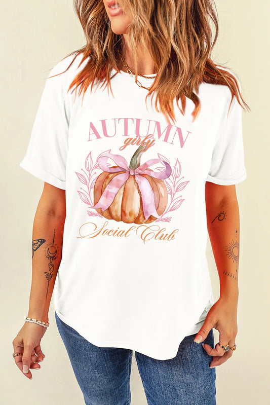 A woman wears a white short-sleeve t-shirt with a pumpkin graphic.