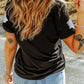 A woman from behind wears a black short-sleeve t-shirt with glitter ghost designs.