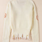 A cream-colored, distressed sweater with pumpkin accents on the sleeves.