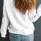 Back view of a woman wearing a white Halloween pumpkin lantern sequin patched sweatshirt.