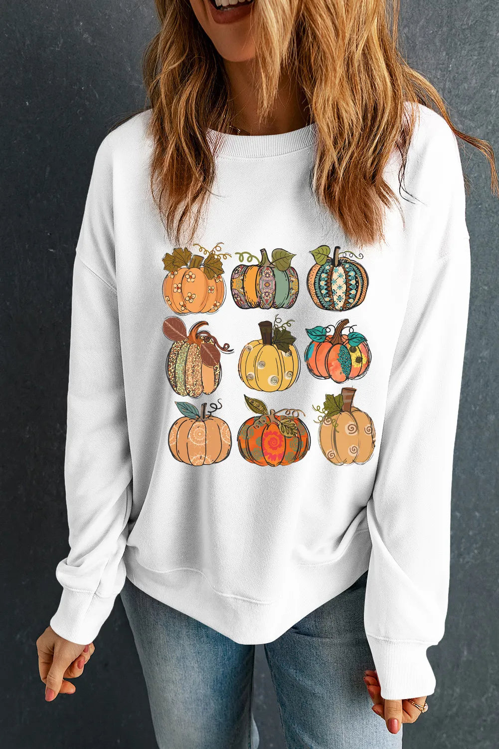 Pumpkin graphic long sleeve sweatshirt on a woman.