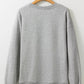 Gray round neck sweatshirt on a wooden hanger.