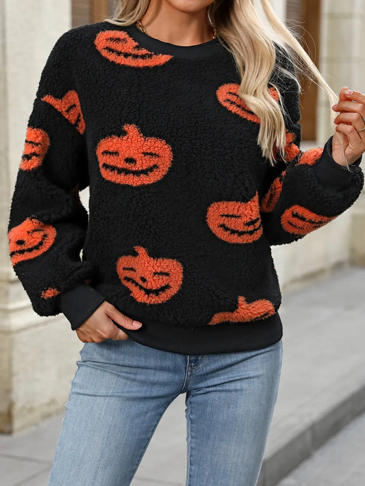 Fuzzy black sweater with orange pumpkin designs, round neck, and dropped shoulders.