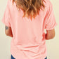 Back view of a woman wearing a pink short-sleeve t-shirt and blue jeans.