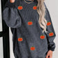 A woman wears a dark gray corduroy long-sleeve sweatshirt with pumpkin appliques.