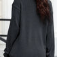 A woman from the back wearing a dark gray ribbed long-sleeve sweatshirt.