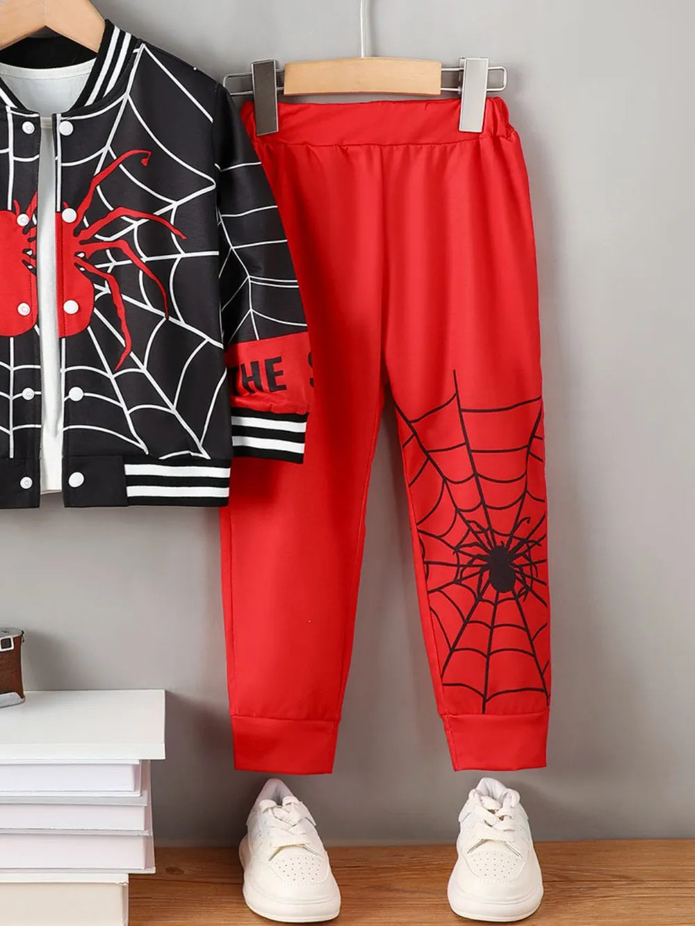 A black and red Spider-Man themed top and pants set with white sneakers.