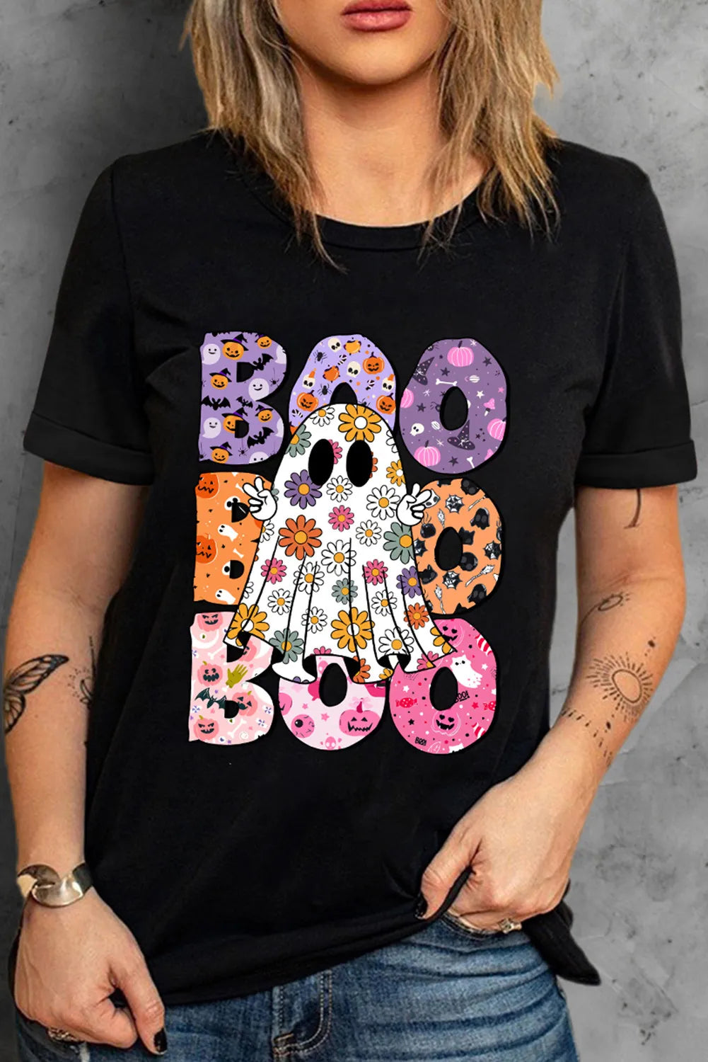 A woman wears a black short-sleeve t-shirt with a colorful "BOO" ghost graphic.