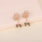 Gold-toned spiderweb and spider earrings with purple and clear rhinestones.